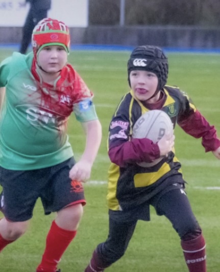 Two boys playing rugby