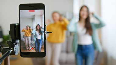 two women dancing while filming on a mobile phone